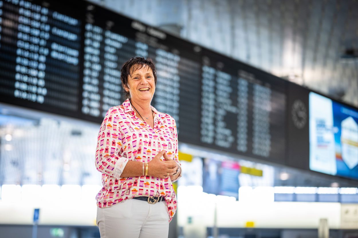 Steffi Christian lachend in einer Flughafenhalle